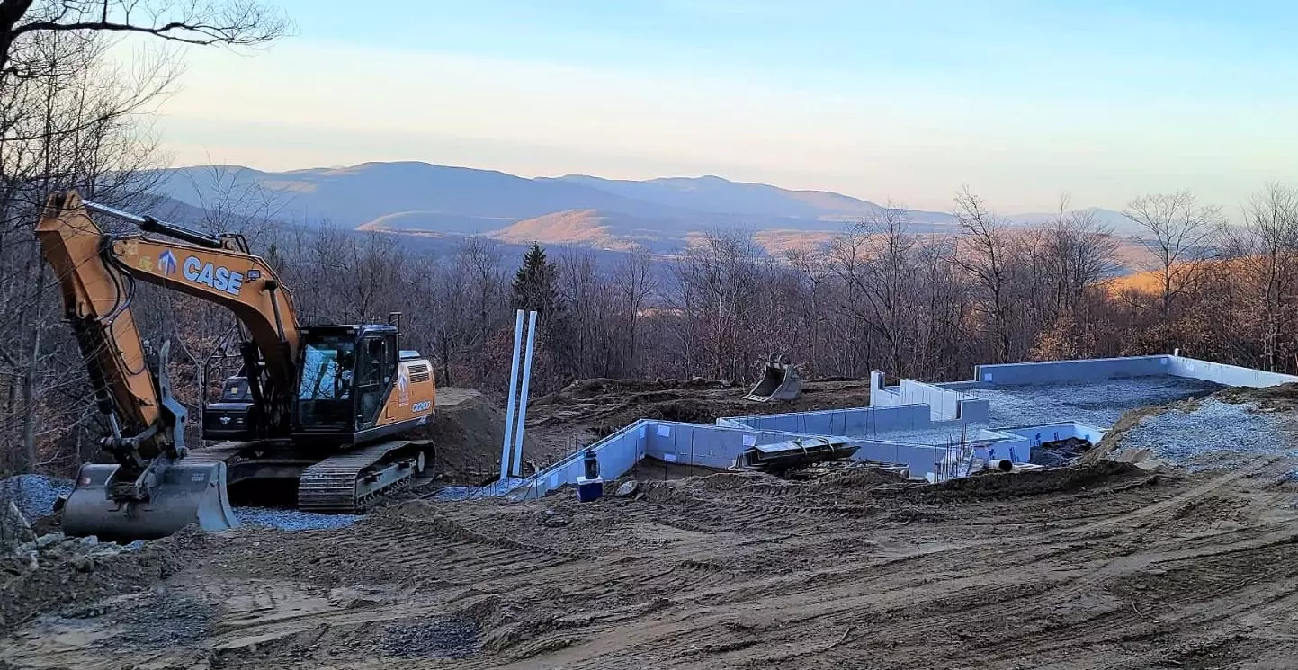 Travaux d’excavation et fondations en Estrie par Les Entreprises Talbot inc – Pelle mécanique CASE en action sur un chantier de construction neuve à flanc de montagne près de Sherbrooke.